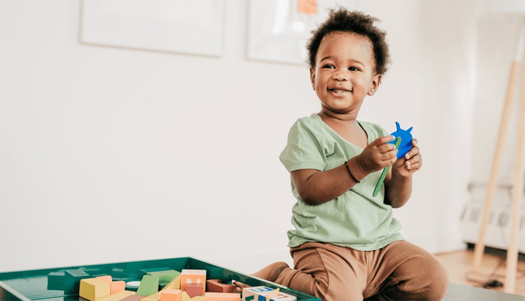 Toddler building a tower with blocks during independent play activities for preschoolers.