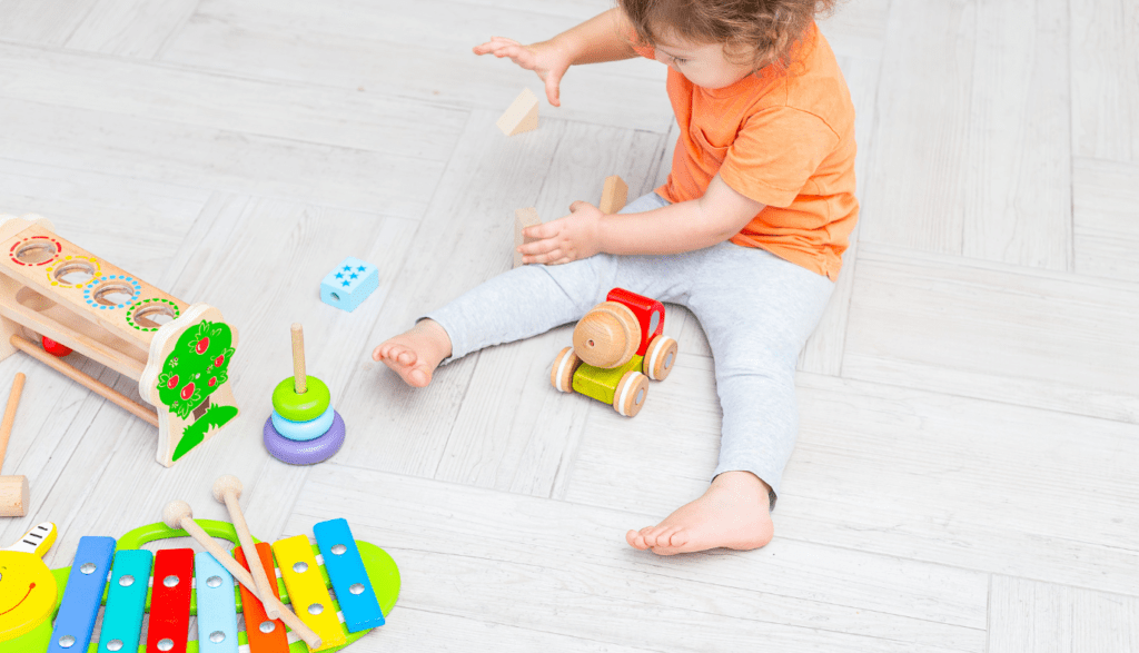 "Toddler exploring musical instruments as part of independent play activities for preschoolers.