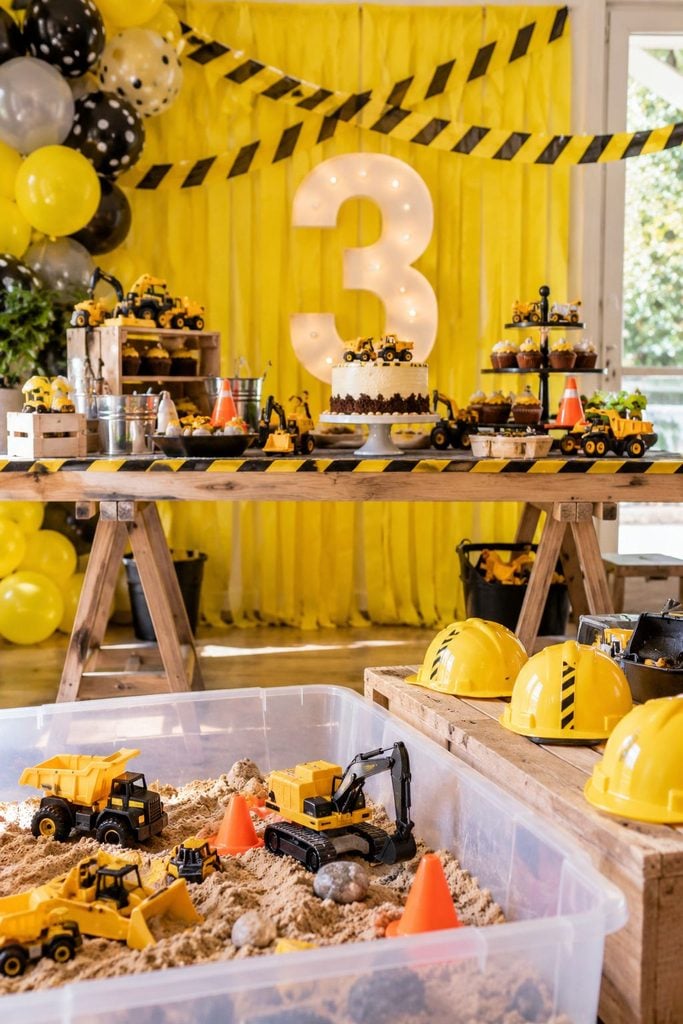 Construction zone birthday party with caution tape streamers and hard hats