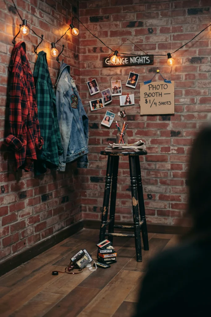 Denim and flannel grunge photo corner with amber string lights for a 90's tween party