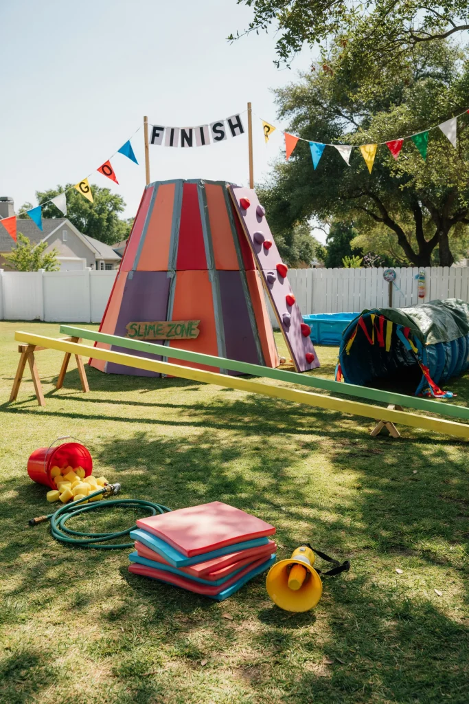 GUTS-style Aggro Crag obstacle course backyard setup for a 90's kids party