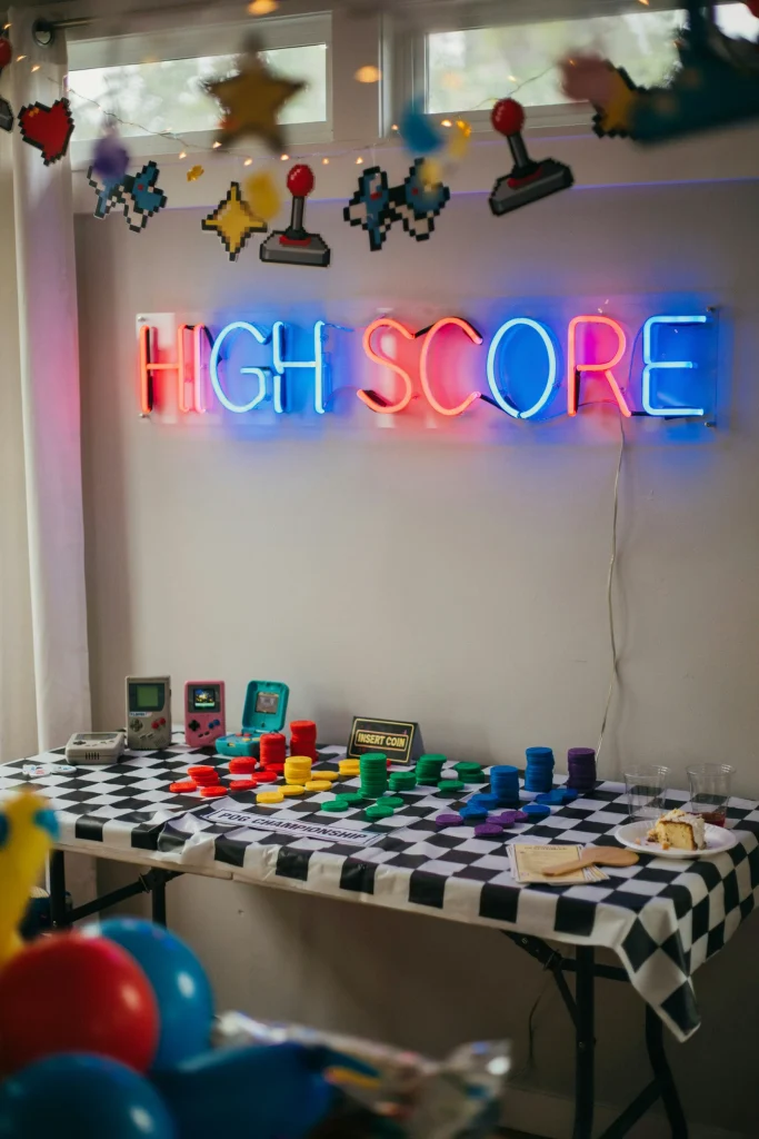 Retro arcade and Pogs game corner set up for a 90's themed kids party
