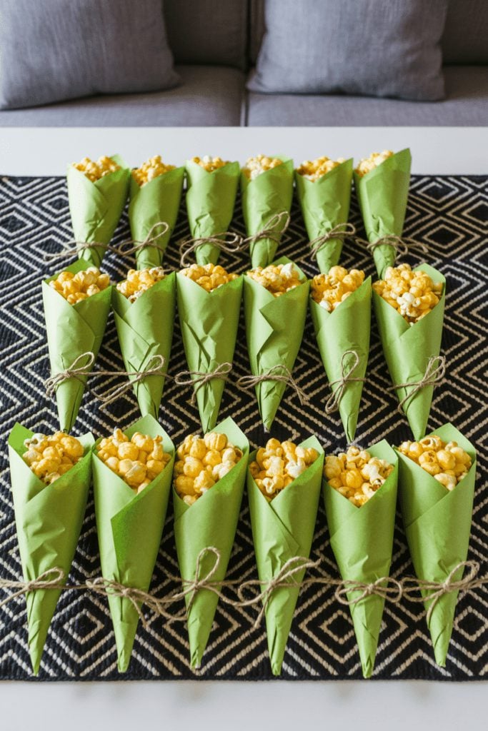 Popcorn served in kraft paper cones tied with twine for a rustic BBQ snack station
