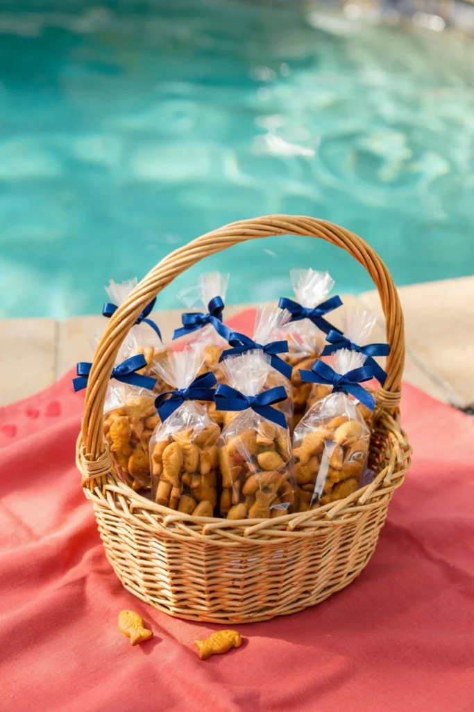 Small resealable bags of orange goldfish crackers tied with blue ribbon in a wicker basket