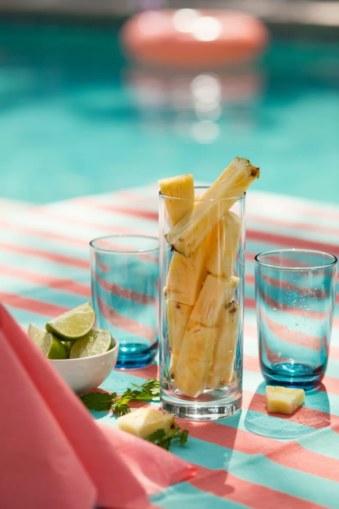 Fresh pineapple cut into thick spears standing upright in a tall glass jar
