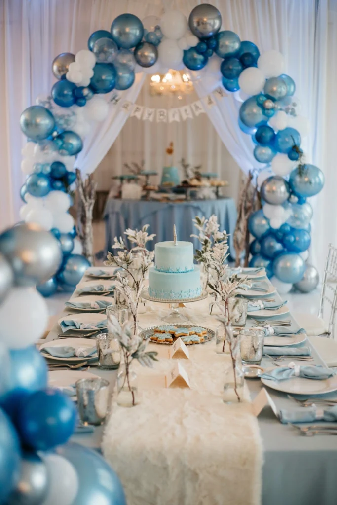A hushed winter ice palace birthday party room styled with faux fur, frosted glass, and silvery pinecones