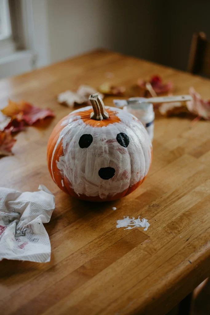 White-painted ghost pumpkin with simple black dot eyes