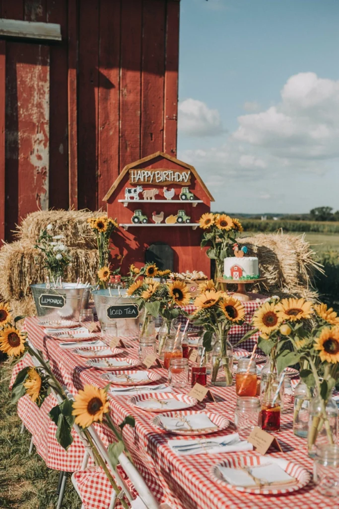A gingham tablecloth and straw bale seating set up for a warm barnyard farm birthday party