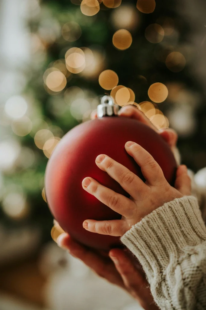 Close-up of baby's hand gripping a large glass ornament