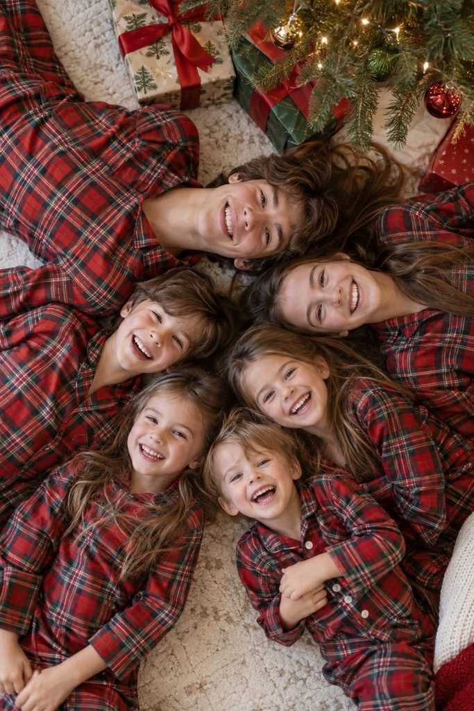 Overhead view of several siblings lying in a circle in Christmas pajamas