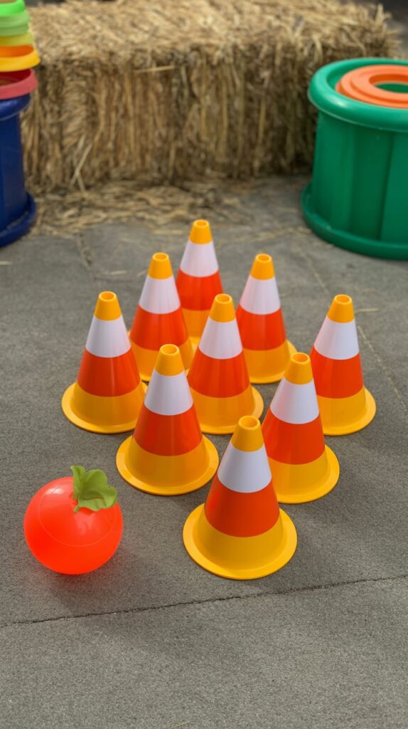 Candy corn bowling setup with small plastic bottles and a mini pumpkin ball.