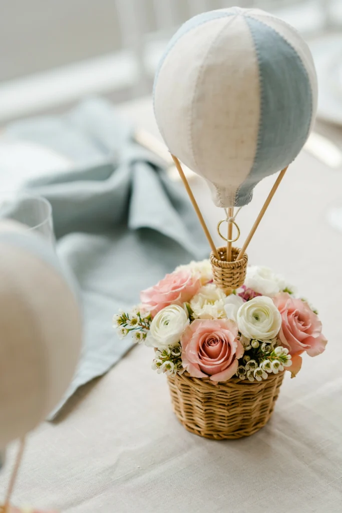 Close up of a wicker basket hot air balloon centerpiece with blush and ivory florals