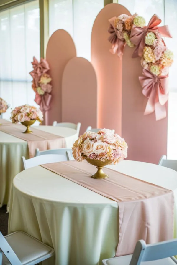 Pink bow baby shower decor with satin bows and blush balloons