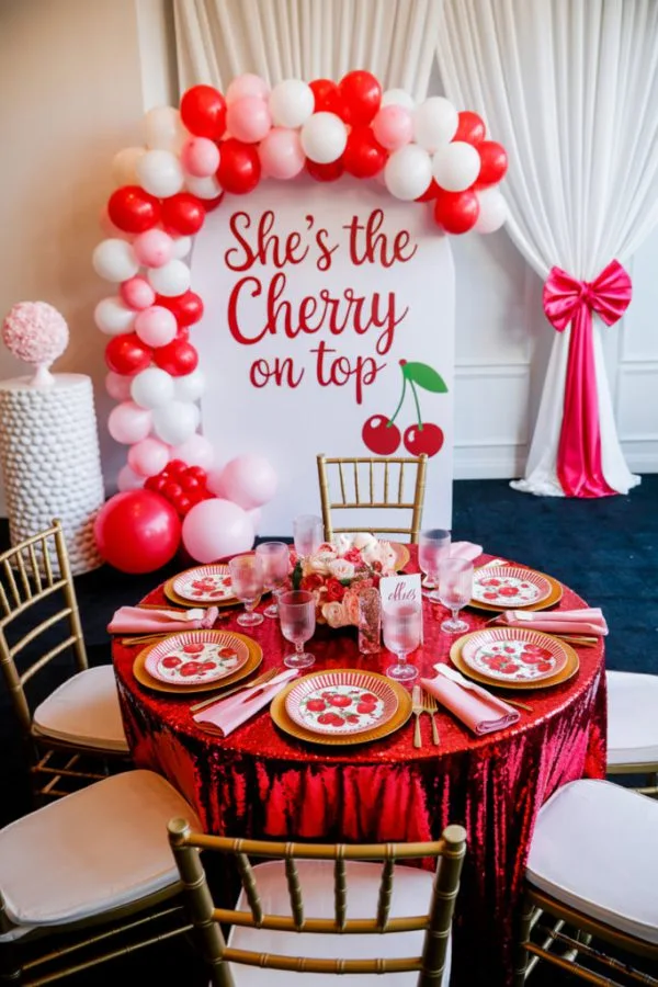 Cherry themed baby shower dessert table with red and pink cherry balloons