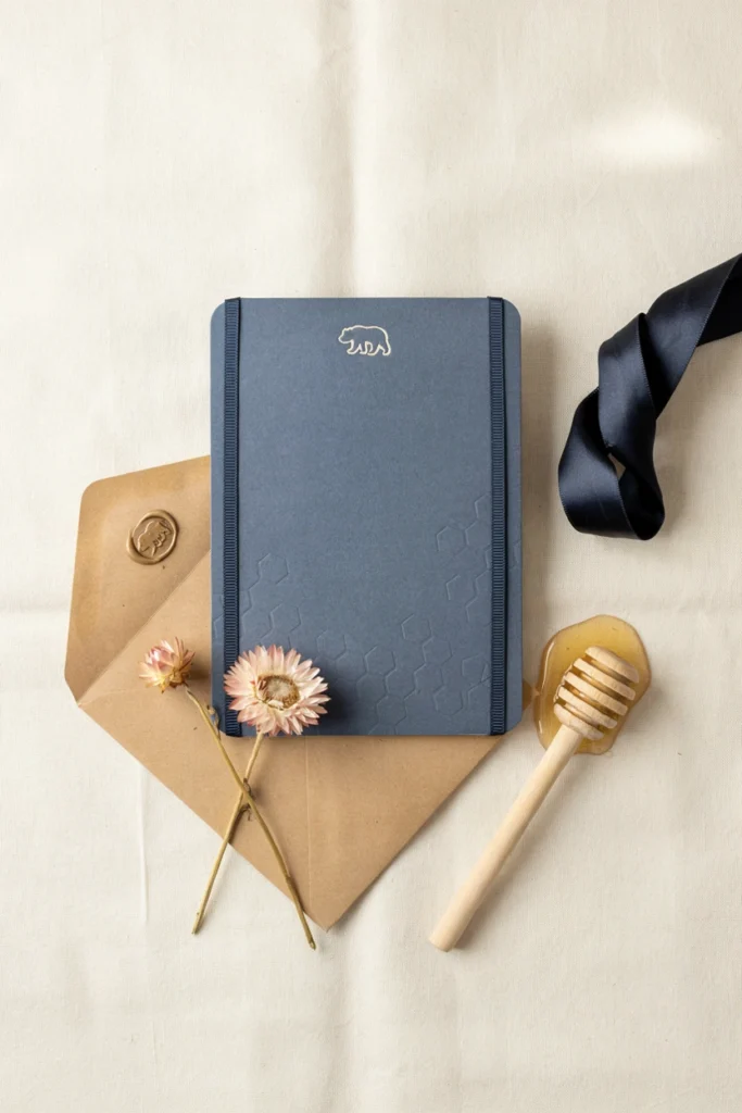 Navy invitation with a gold bear silhouette and a cocoa envelope lined in cream tissue paper