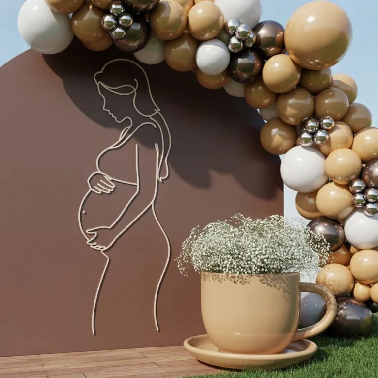 Neutral balloon backdrop with line art coffee mug illustration for a baby shower
