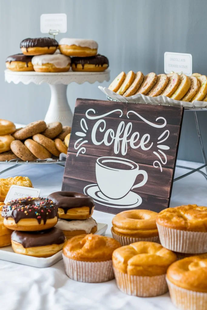 Coffee themed dessert table with donuts muffins and pastries