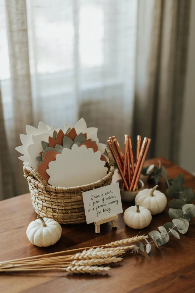 A basket of leaf-shaped cardstock cards where guests write advice, tucked next to a pen and small sign