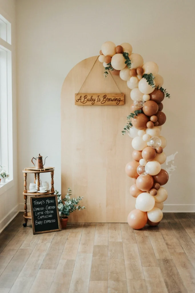 Coffee shop photo booth installation with arched panel, balloon garland and coffee cart prop