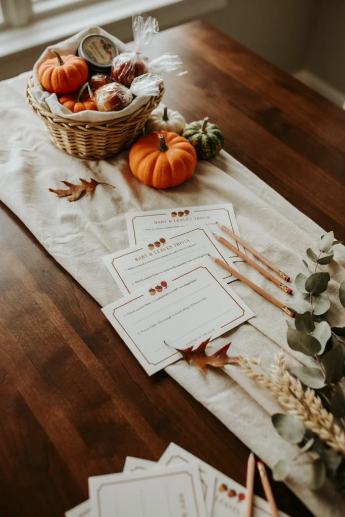 A printed trivia card set on a table featuring fall facts and baby-related questions with a small prize basket nearby