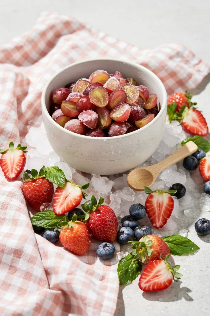 Bowl of frozen red grapes styled to look like a bowl of berries