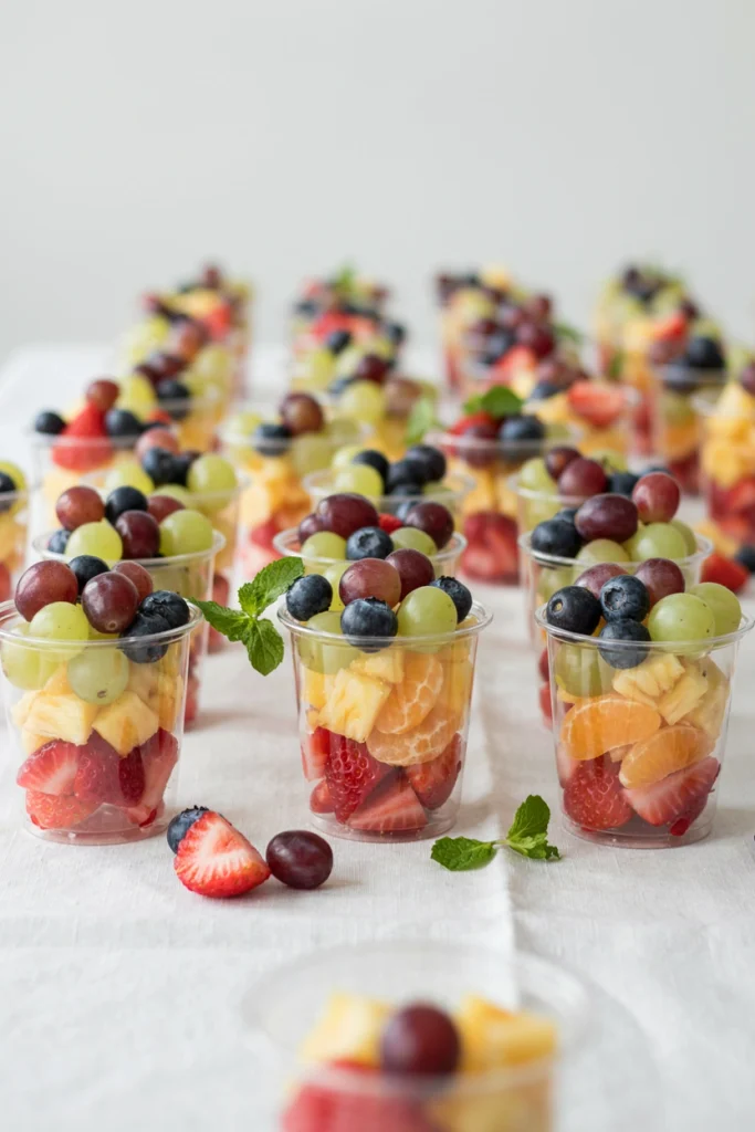 Individual clear cups layered with rainbow fruit for a grab-and-go party snack