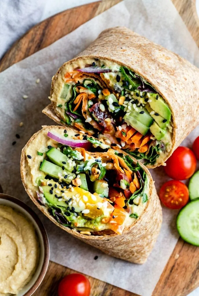 Veggie hummus wrap sliced open showing colorful vegetables