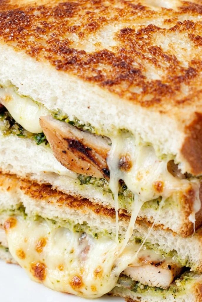 Grilled chicken pesto sandwich with melted cheese on toasted bread