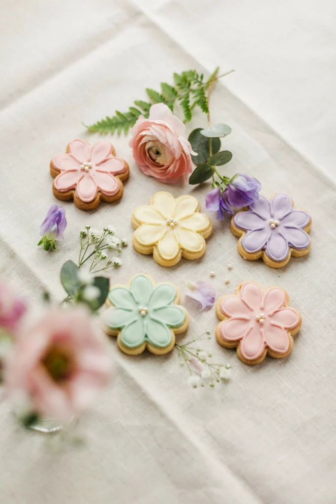 Flower-shaped sugar cookies dusted with pastel edible glitter on a plate