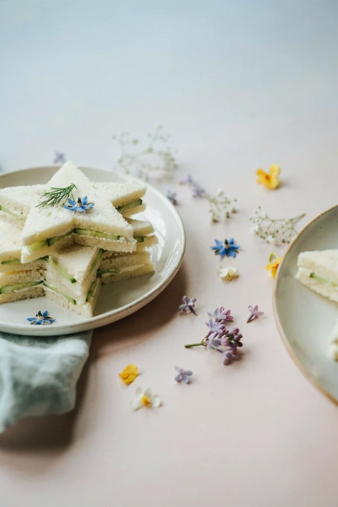 Tea sandwiches cut into star shapes and stacked on a platter for a fairy first birthday party