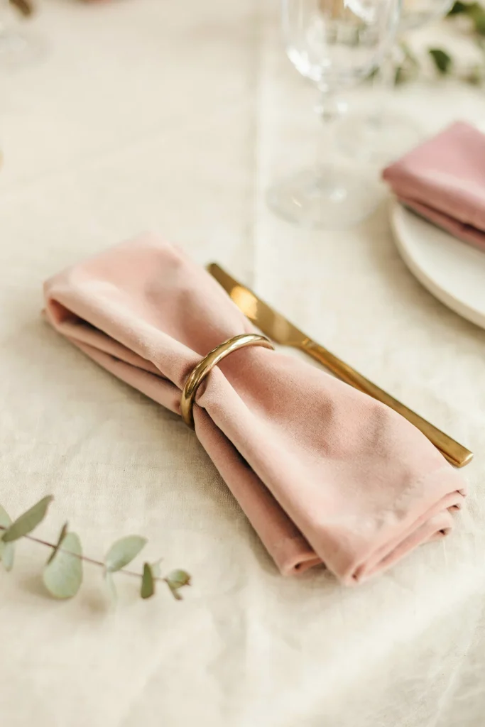 A luxurious table setting with blush velvet tablecloth or blush velvet napkins paired with ivory linens. Close-up of the fabric texture showing the pile and richness of velvet. Elegant, tactile, sophisticated