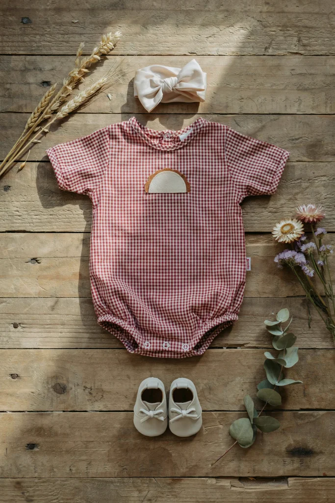 Baby in a gingham romper with a felt pie slice applique for a cutie pie first birthday