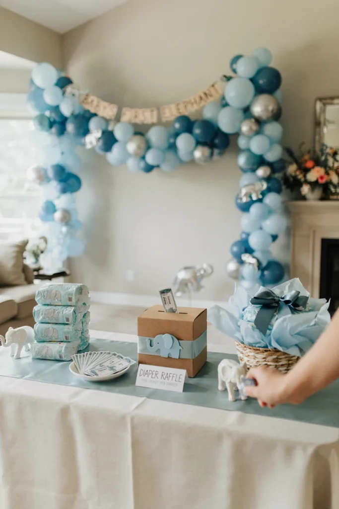 Blue elephant diaper raffle box and tickets on a gift table
