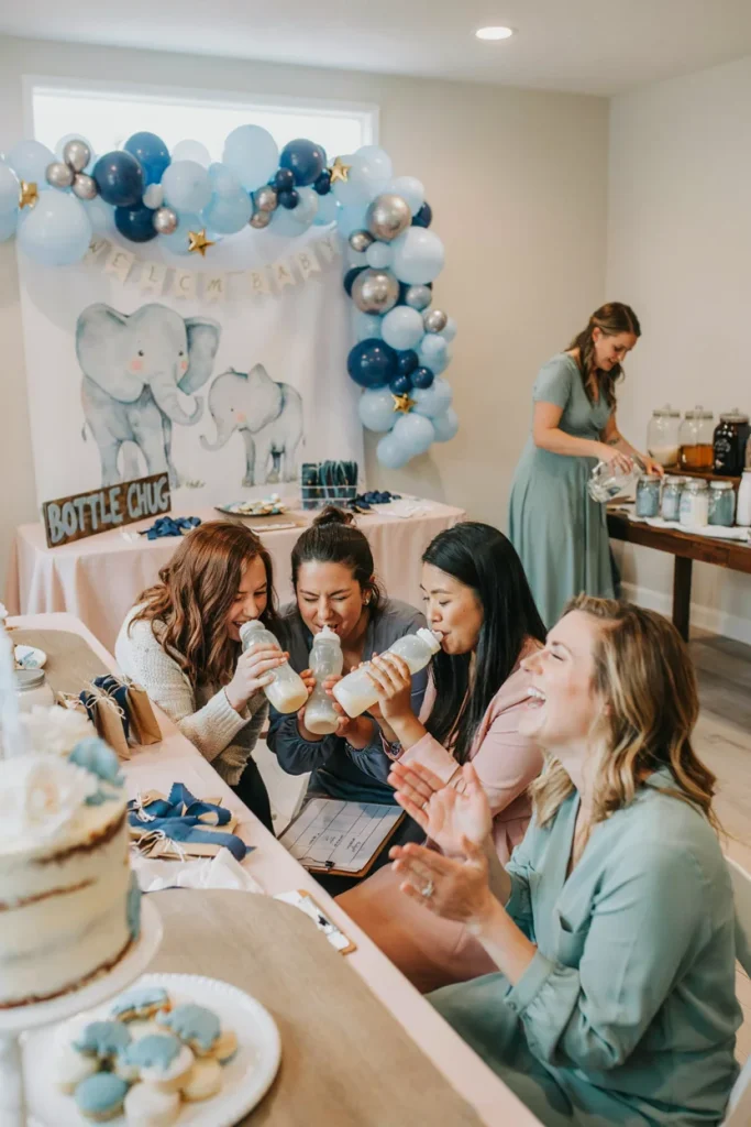 Guests playing the bottle chug race game at a baby shower
