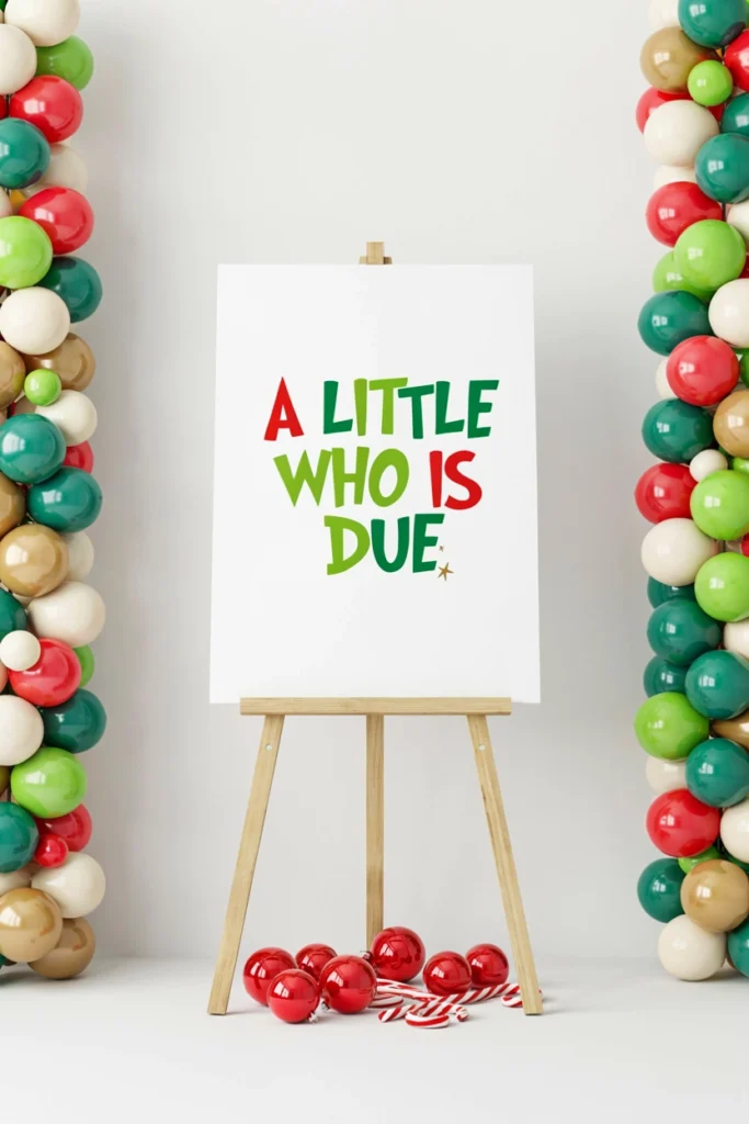 A Little Who Is Due easel sign in red and green lettering at a Grinch baby shower