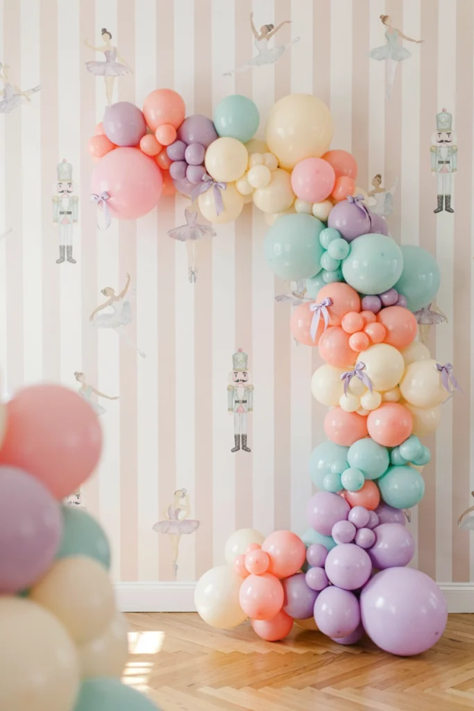 Pastel balloon garland arch with nutcracker and ballerina baby shower backdrop