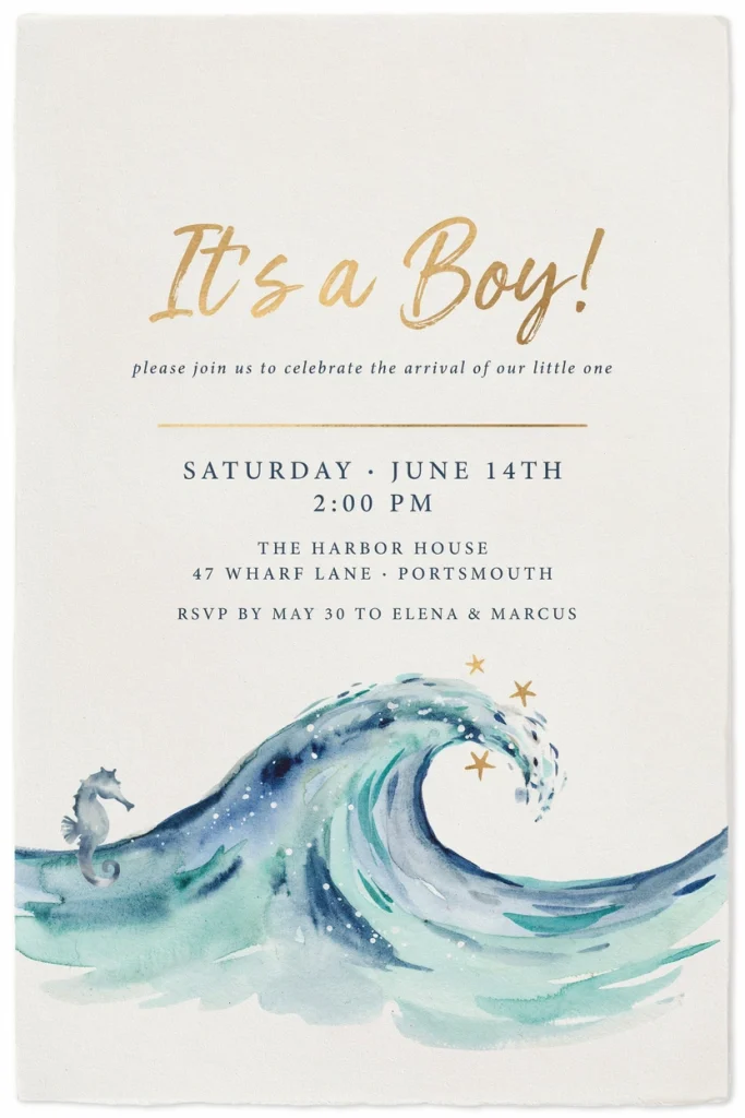 A cream cardstock baby shower invitation with a soft watercolor wave washing across the bottom edge in blue and seafoam tones, gold script lettering above