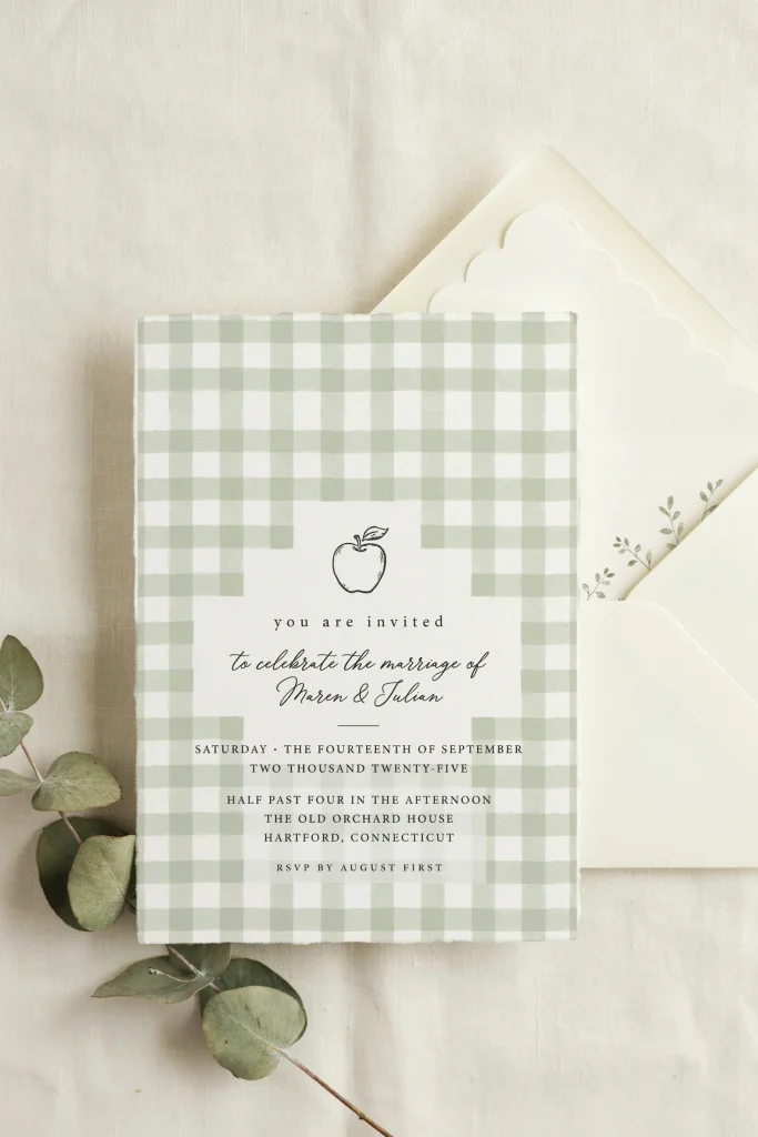 Green gingham apple baby shower invitation flat lay