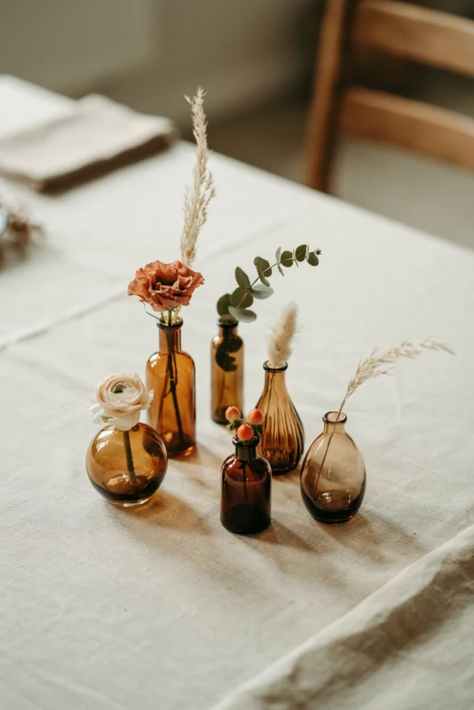 Amber glass bud vases with single stem florals for a fall baby shower centerpiece