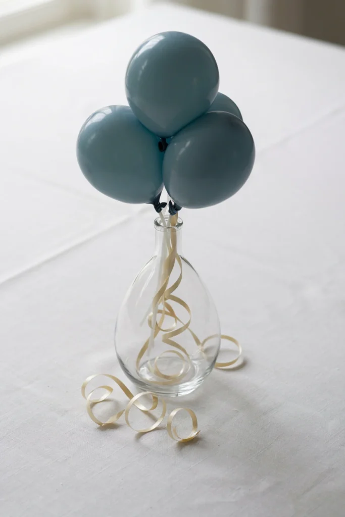 Dusty blue balloon bud vase bouquet with curling ribbon stems for a baby shower centerpiece