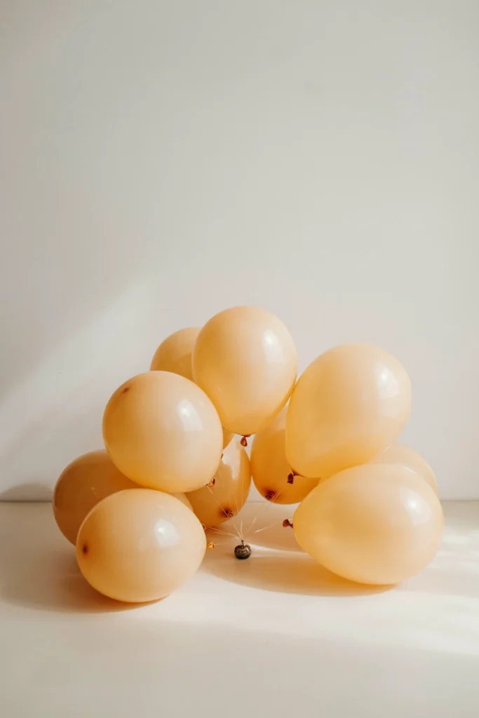 Low pastel yellow balloon starburst centerpiece in mixed sizes for a baby shower table