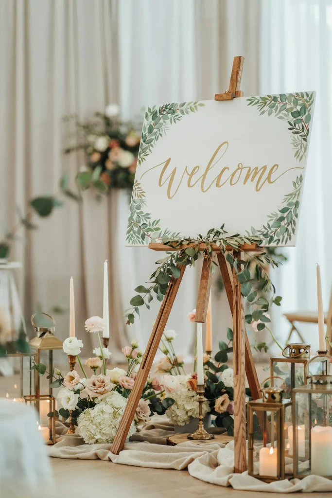 Hand-painted wooden welcome baby sign with a sage green botanical border
