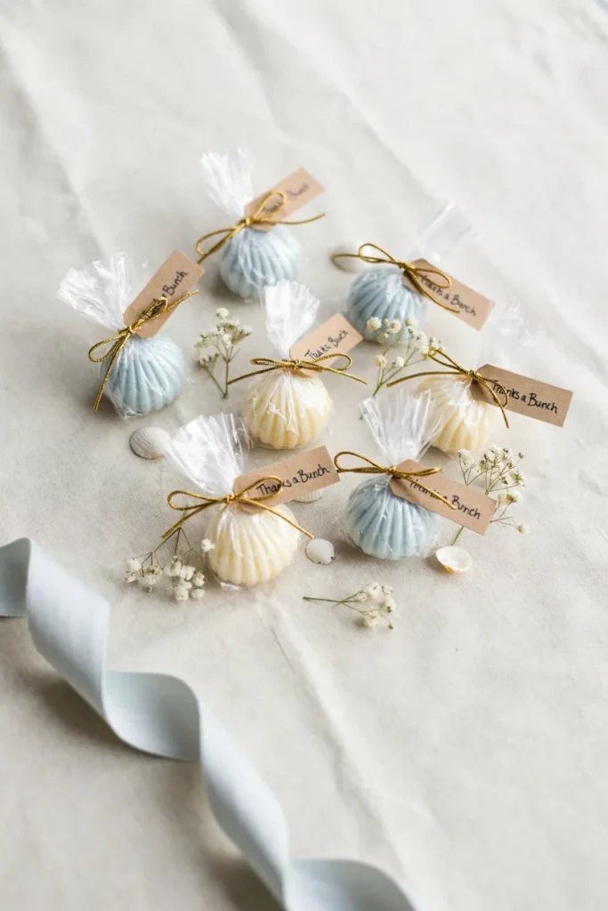 Small individually wrapped shell-shaped soaps in pale blue and cream, tied with gold twine and tagged "Thanks a Bunch"