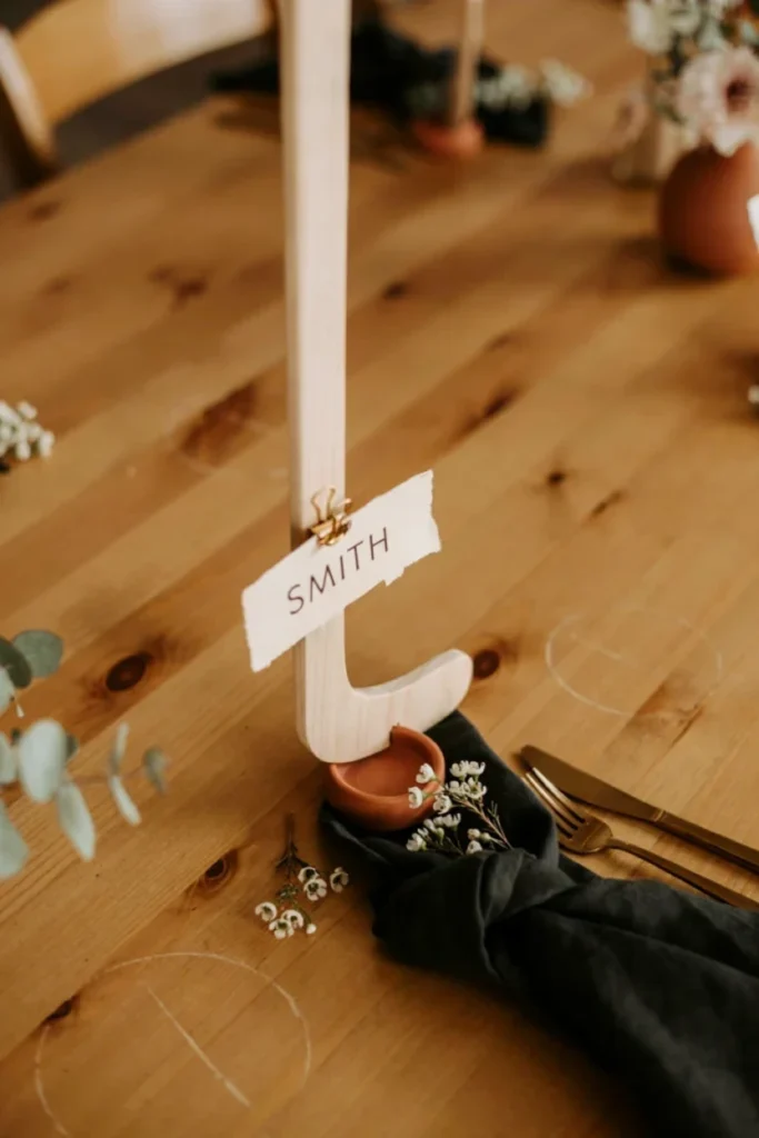 Mini wooden hockey stick place card holders on a hockey baby shower table