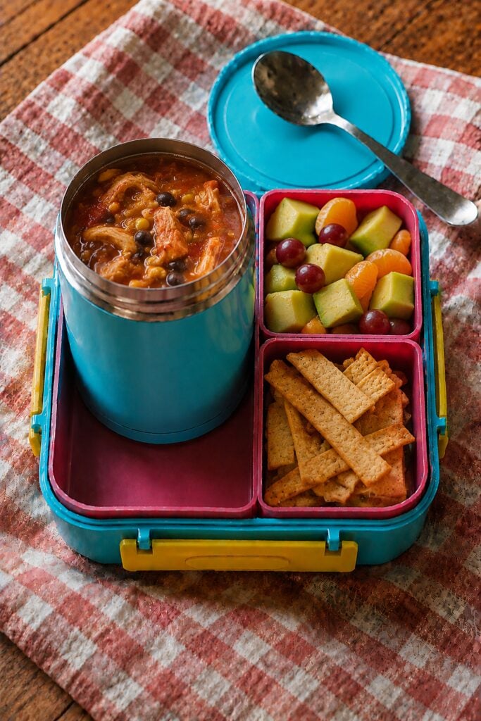 Chicken tortilla soup topped with crushed chips in a thermos