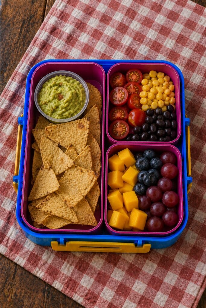 Tortilla chips beside a guacamole cup