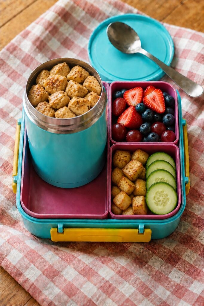 Golden chicken cubes glazed in honey mustard in a thermos