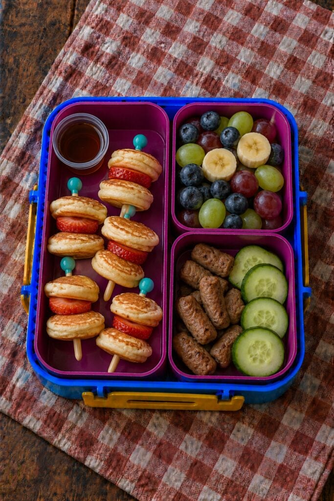 Mini pancakes stacked on skewers with syrup dip