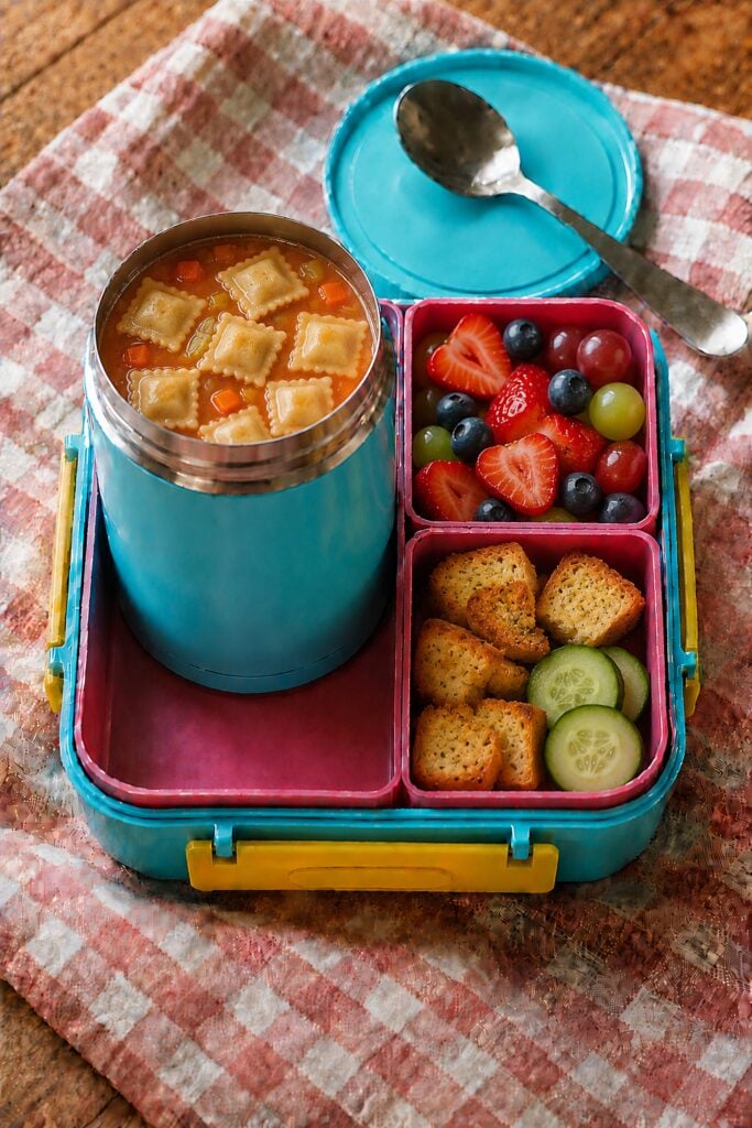 Small cheese ravioli in tomato broth in a thermos