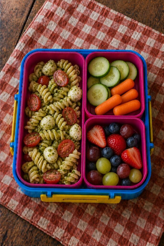 Rotini pasta tossed in pesto with cherry tomatoes